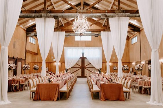 a rustic, wood event space accented with modern, chiffon draping
